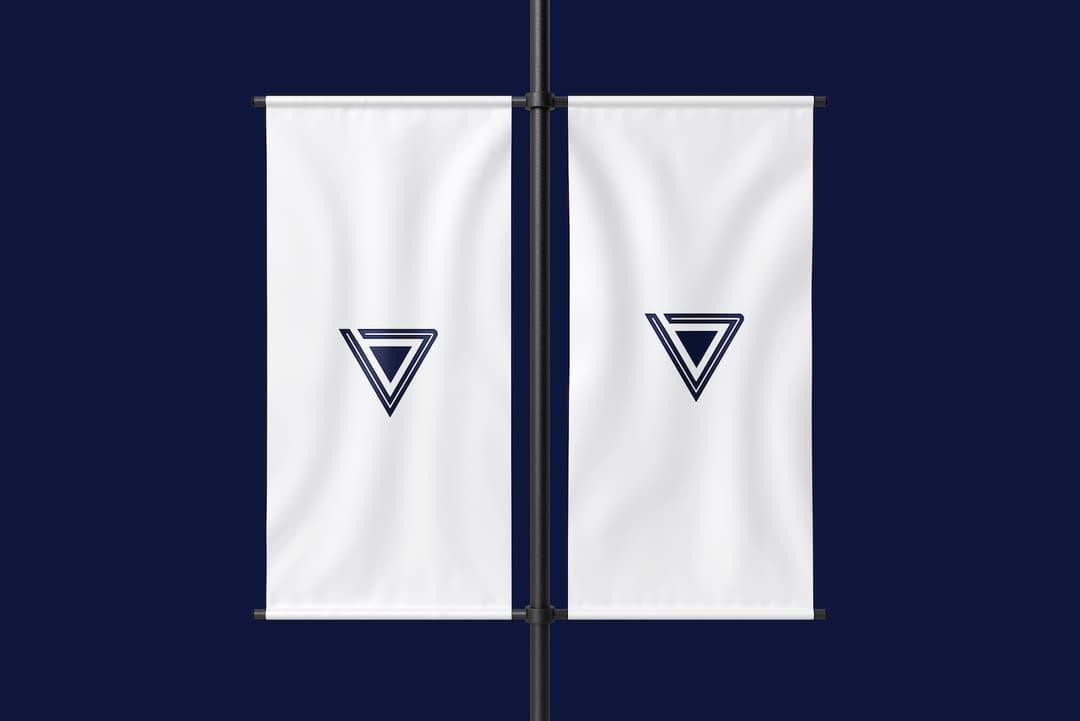 Dos estandartes colgantes blancos con el logotipo de Punto Clave en azul oscuro en el centro, montados en postes verticales y colocados uno al lado del otro contra un fondo azul oscuro