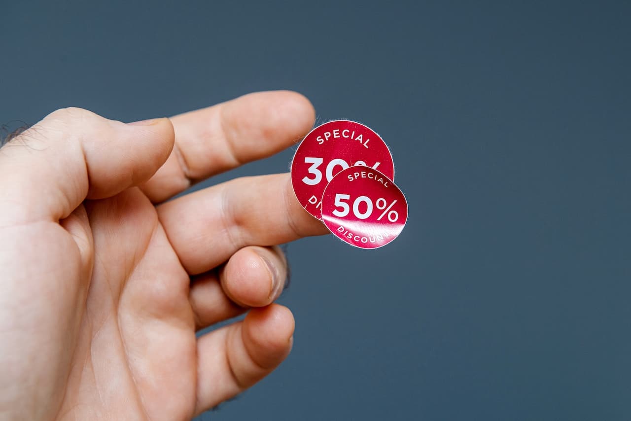 Se observa una mano sosteniendo dos etiquetas rojas con descuentos, una que dice '30%' y otra '50%', ambas etiquetadas como 'SPECIAL DISCOUNT'. La imagen transmite una sensación de ofertas y promociones, destacando la marca 'punto clave'.
