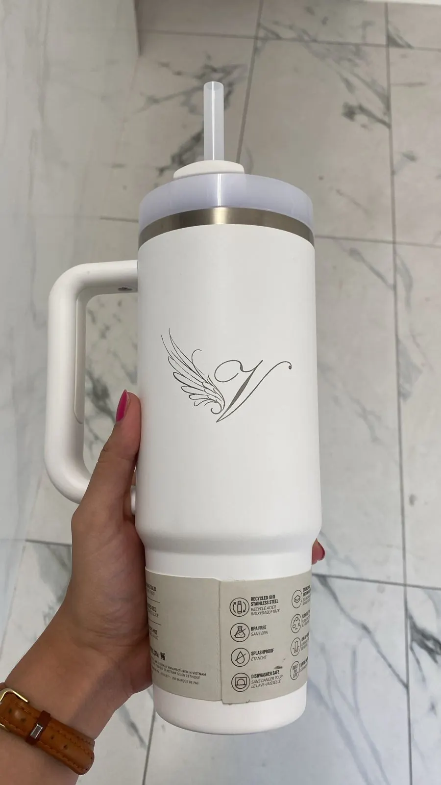 Termo blanco con asa grabado con láser con una inicial y un ala en trazo fino