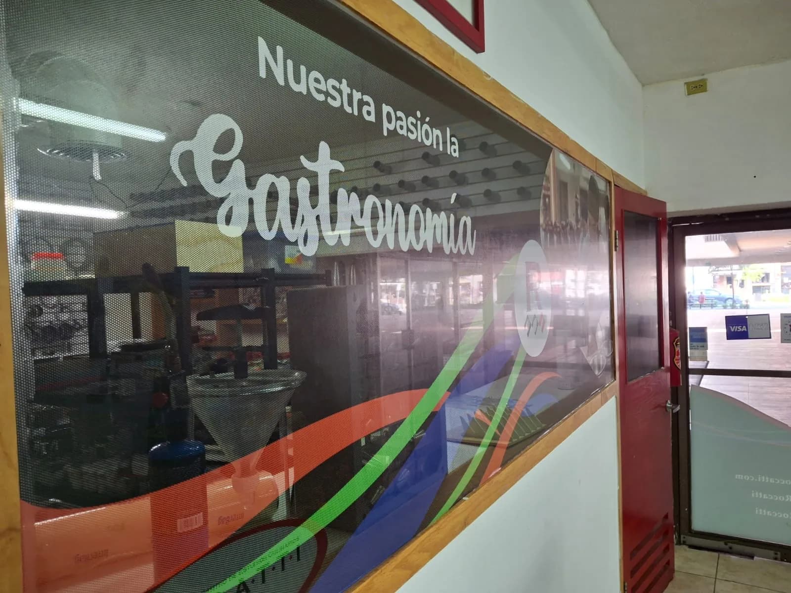 Letras y logotipo en vinil de corte blanco y verde aplicados sobre el cristal de un restaurante